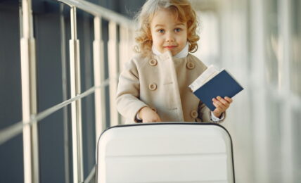 Devojčica na aerodromu drži pasoš u ruci